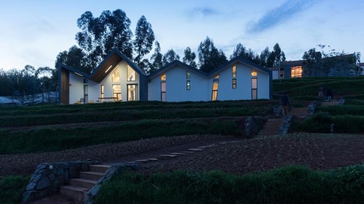 Photo of Butaro Doctors' Sharehousing, Photo by Iwan Baan, Exterior Evening View of the Hill Side and a Housing Unit