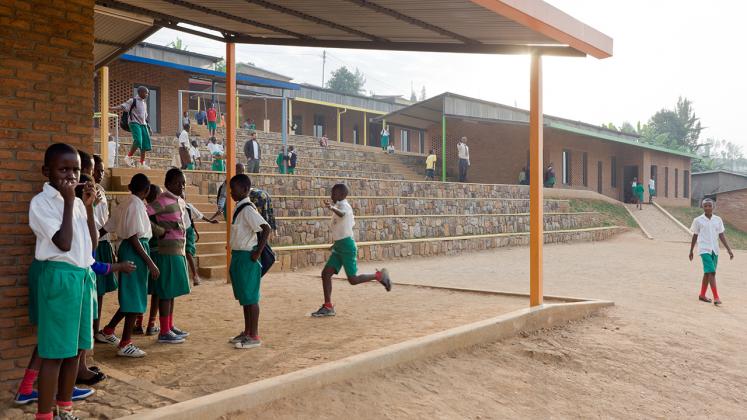 Photo of the Umubano Primary School, Photo by Iwan Baan, View of Tiered Landscape and School Children Playing
